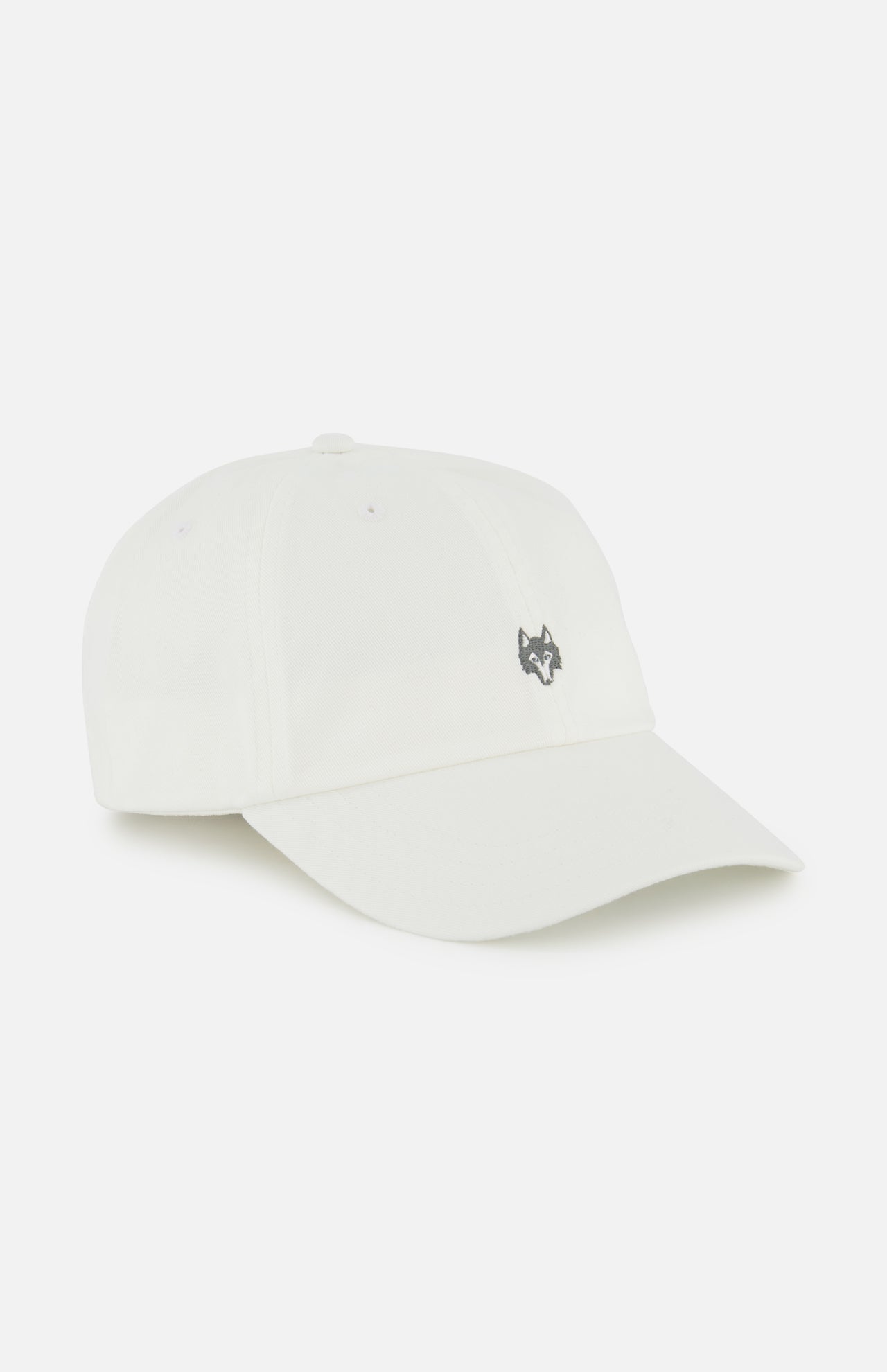 The GREYSON Icon Dad Hat is a white cotton twill cap with a small black embroidered wolf head above the brim, curved visor, visible stitching, and an adjustable strap for a perfect fit.