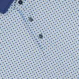 Close-up of the GREYSON Ironwood Polo Shirt, showcasing a blue and white geometric dot pattern, three dark buttons, a solid blue collar, and moisture-wicking fabric for comfort.