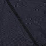 Close-up of the GREYSON Micro Icon Trailwolf Hybrid Sport Vest, showcasing its dark, subtly dotted fabric and diagonal zipper. The visible texture highlights its lightweight design, making it an ideal versatile outer layer for transitional weather.