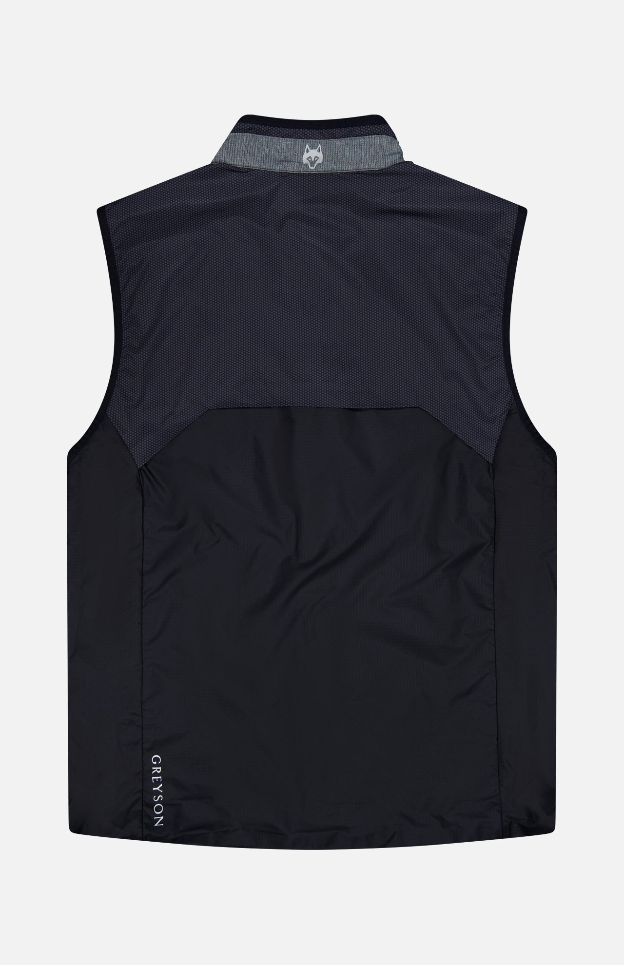 The GREYSON Micro Icon Trailwolf Hybrid Sport Vest in black and dark gray is shown laid flat with a view of the back. Featuring a subtle logo at the upper neck and “GREYSON” lettering near the bottom left hem, this sleeveless vest is an ideal lightweight outer layer for transitional weather, combining style with versatile performance.