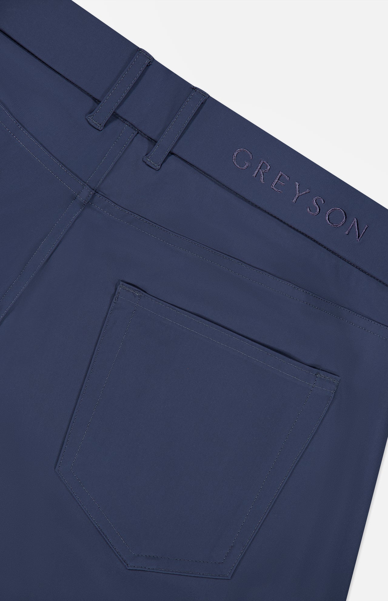 Close-up of the back pocket and waistband of the Montauk 5 Pocket Pant by GREYSON, crafted from luxurious Italian fabric, with GREYSON embroidered above the pocket.