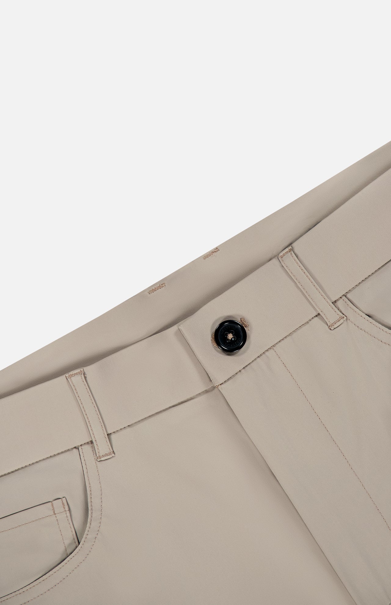 The Montauk 5 Pocket Pant by GREYSON is displayed diagonally, showcasing a black button, visible belt loops, pockets, and detailed stitching. Expertly crafted from premium Italian fabric with a smooth finish, these beige trousers offer an elegant contrast against the plain white background.