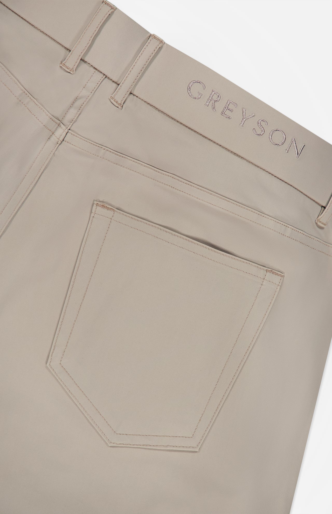 Close-up of the back pocket and waistband of the Montauk 5 Pocket Pant by GREYSON, featuring GREYSON embroidered above the pocket and crafted from premium Italian fabric for exceptional comfort and style.