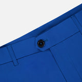 Close-up of the waistband and upper section of GREYSON Montauk 8-Way Stretch Trouser in bright blue, featuring a black button, belt loops, and partial pocket detail, set against a plain light background.