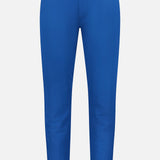 The Montauk 8-Way Stretch Trouser by GREYSON is a bright blue, slim-fit pant made from premium Italian fabric with a single button and zip closure at the waist. Displayed on a plain white background, it features no visible patterns or extra details.