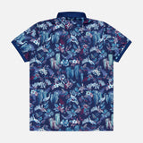 The GREYSON Night Lurk Polo Shirt is a navy short-sleeve performance polo with an all-over tropical floral and foliage print in blue, teal, and pink shades. Moisture-wicking comfort. Shown laid flat from the back view.