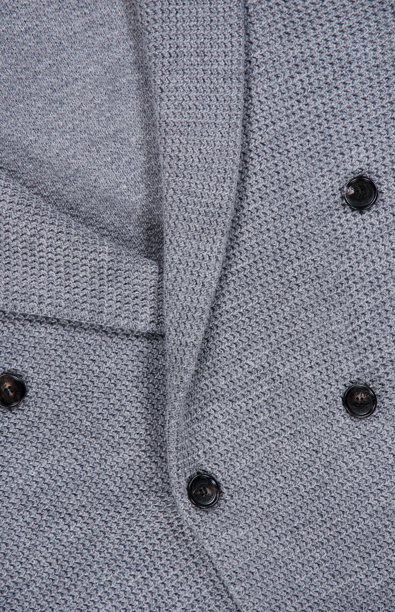 Close-up of the textured gray fabric in a woven pattern, complete with six black buttons arranged in a double-breasted style—ideal for smart-casual ensembles, the GREYSON Saratoga Double Breasted Blazer Cardigan showcases modern sophistication.