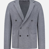 The Saratoga Double Breasted Blazer Cardigan by GREYSON is crafted from soft merino wool in grey. This smart-casual knit blazer features a double-breasted front with black buttons, two front pockets, and a notched lapel, and is displayed against a white background.