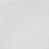 Close-up of the GREYSON Orion Long Sleeve in plain white, featuring a slim fit, smooth fabric texture, and classic crew neckline; a portion of the black clothing label is visible in the upper left corner.