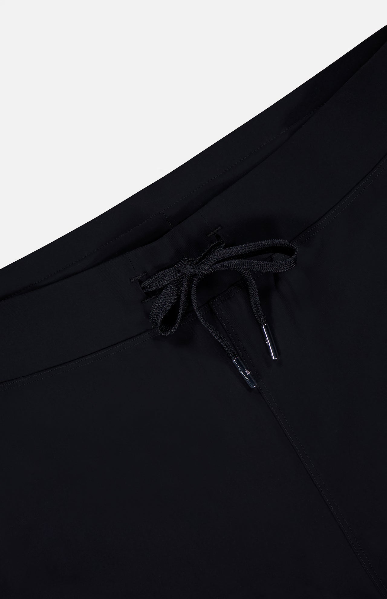 Close-up of the GREYSON Phoenix Jogger in black, showcasing its lightweight fabric and drawstring waistband with metal aglets, set against a plain white background.