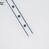 Close-up of the GREYSON Slim Fit Luxe Scarlett Polo in white, featuring a striped dark grey collar and four dark buttons on the placket, shown against a plain white background.