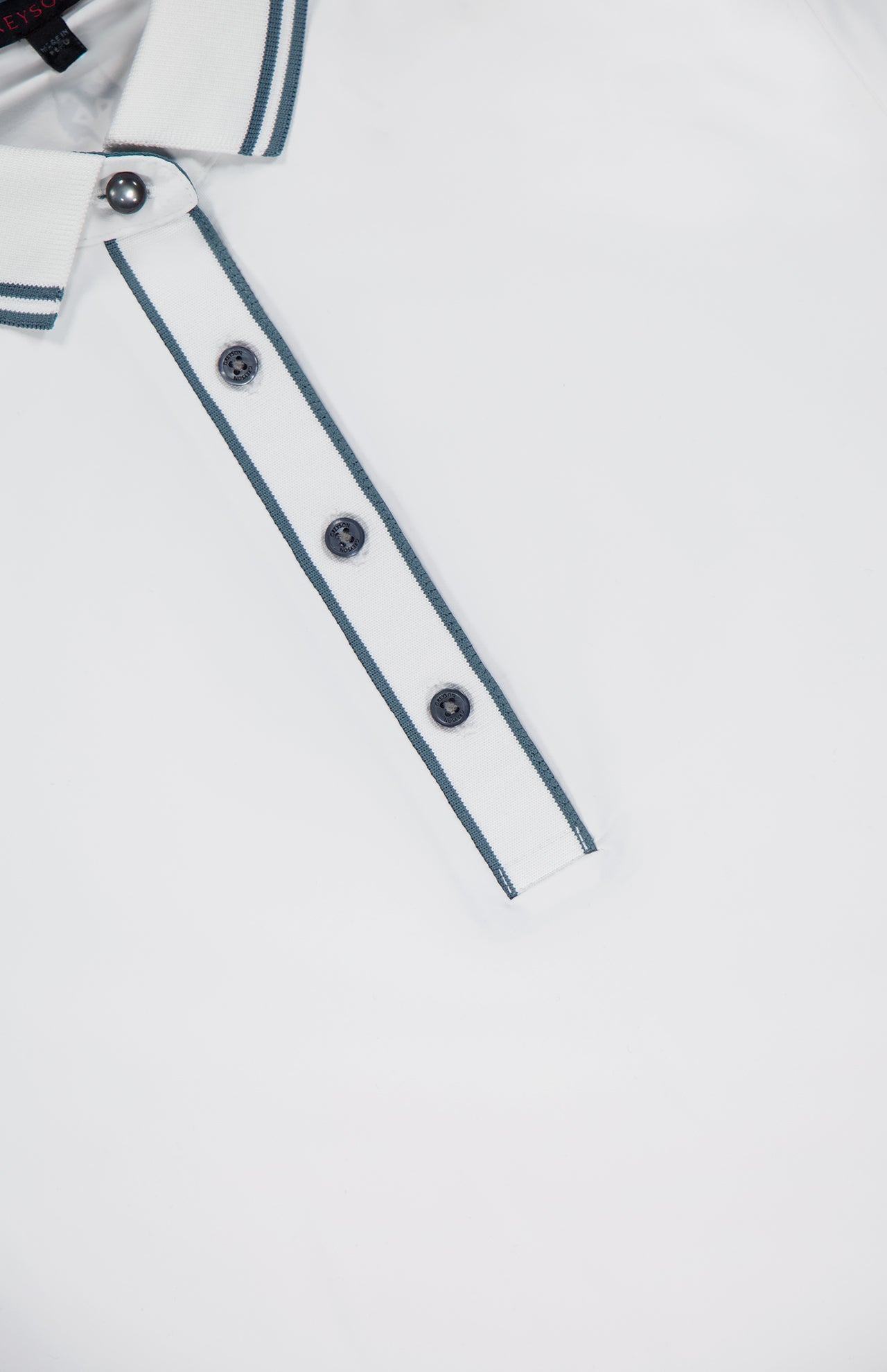 Close-up of the GREYSON Slim Fit Luxe Scarlett Polo in white, featuring a striped dark grey collar and four dark buttons on the placket, shown against a plain white background.