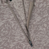 A close-up of the GREYSON Midas Wolf Jacquard Halley II Quarter Zip in light brown and beige jacquard, showcasing the partially unzipped quarter-zip neckline, visible inner lining, and brand tag near the collar.