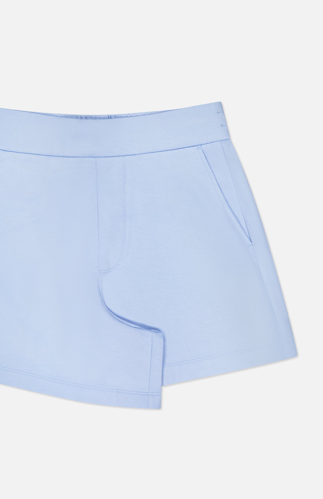 The GREYSON Ojai Trouser Short for women features a light blue, soft cotton-blend fabric, an elastic waistband, and side pockets. Shown on a plain white background with only the upper portion and left side of these comfy mid-rise shorts visible.