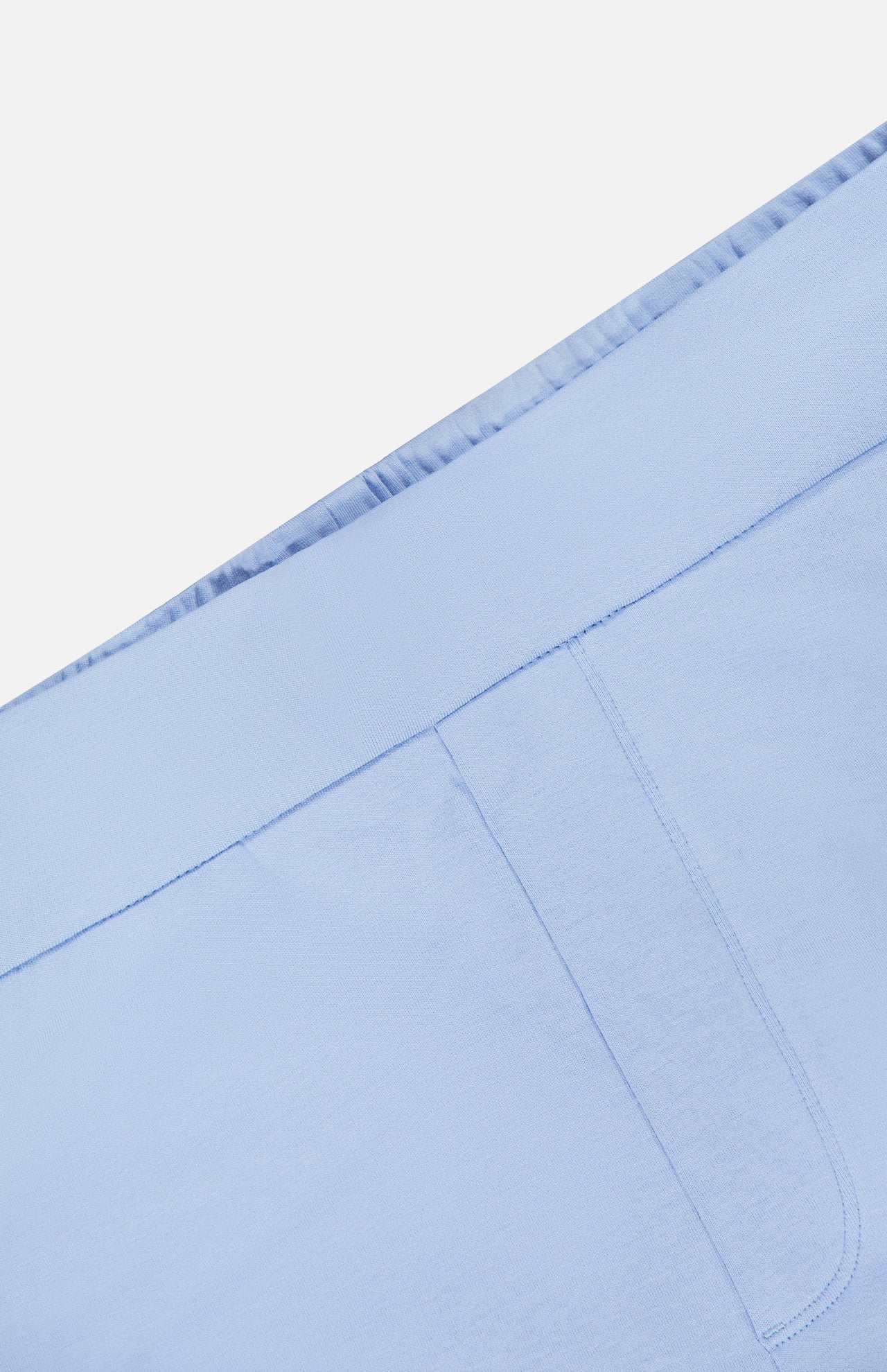 Close-up of the GREYSON Ojai Trouser Short in light blue, showcasing an elastic waistband, visible seam, and pocket on smooth cotton-blend fabric.