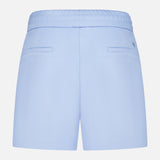 The GREYSON Ojai Trouser Short is shown from the back in light blue, featuring an elastic waistband, two horizontal slit pockets, and a clean, casual design made from a soft cotton blend for everyday comfort.