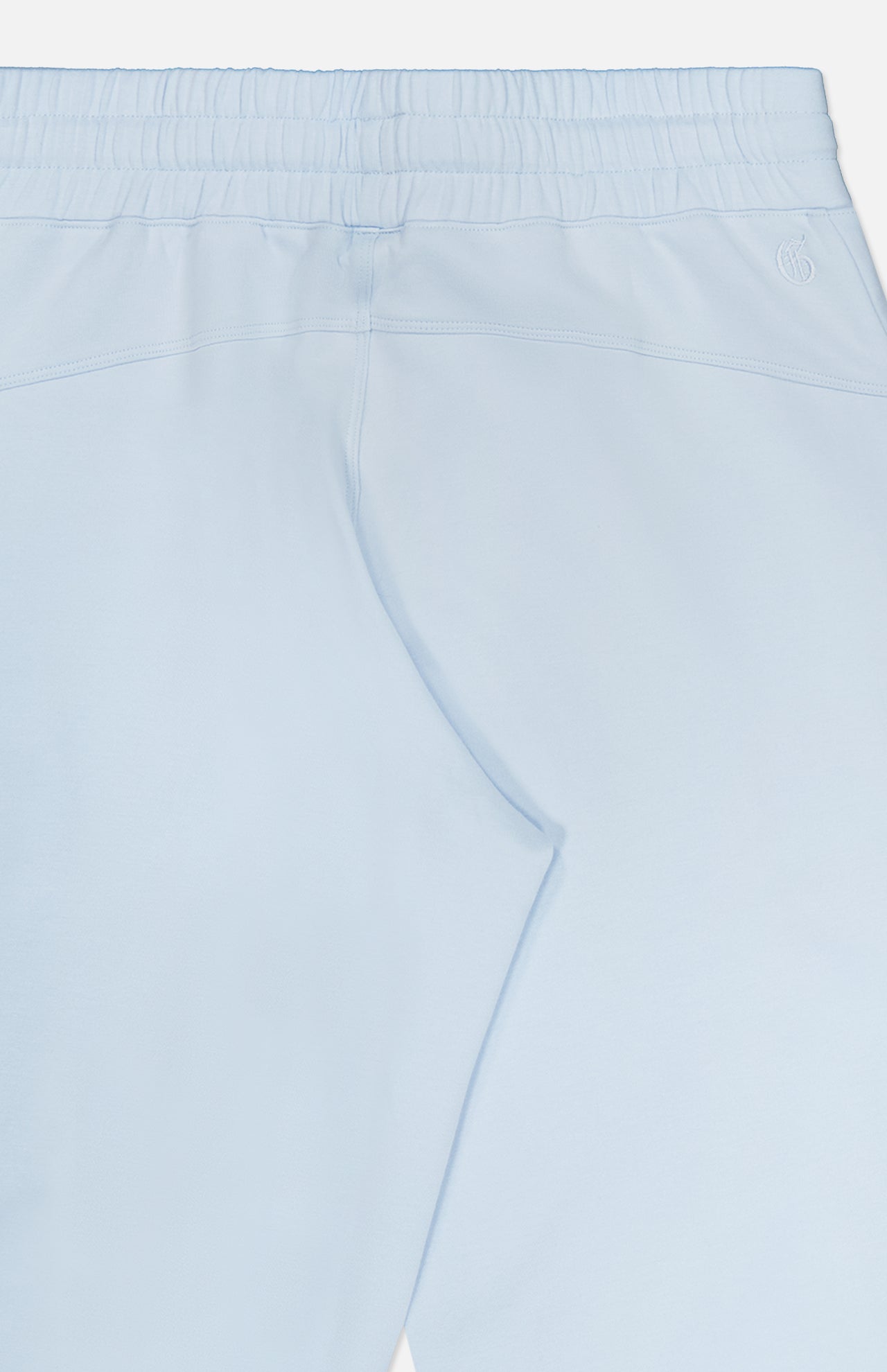 The Ojai Wide Leg Pant by GREYSON is shown here in light blue from the back, featuring an elastic waistband and subtle stitching details. Crafted from a soft and stretchy cotton-blend fabric, these pants offer a jogger-inspired look with a relaxed fit for optimal comfort.