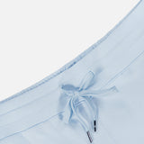 Close-up of the Ojai Wide Leg Pant by GREYSON, featuring a light blue cotton-blend waistband with a matching drawstring finished with silver metal tips, set against a plain white background.