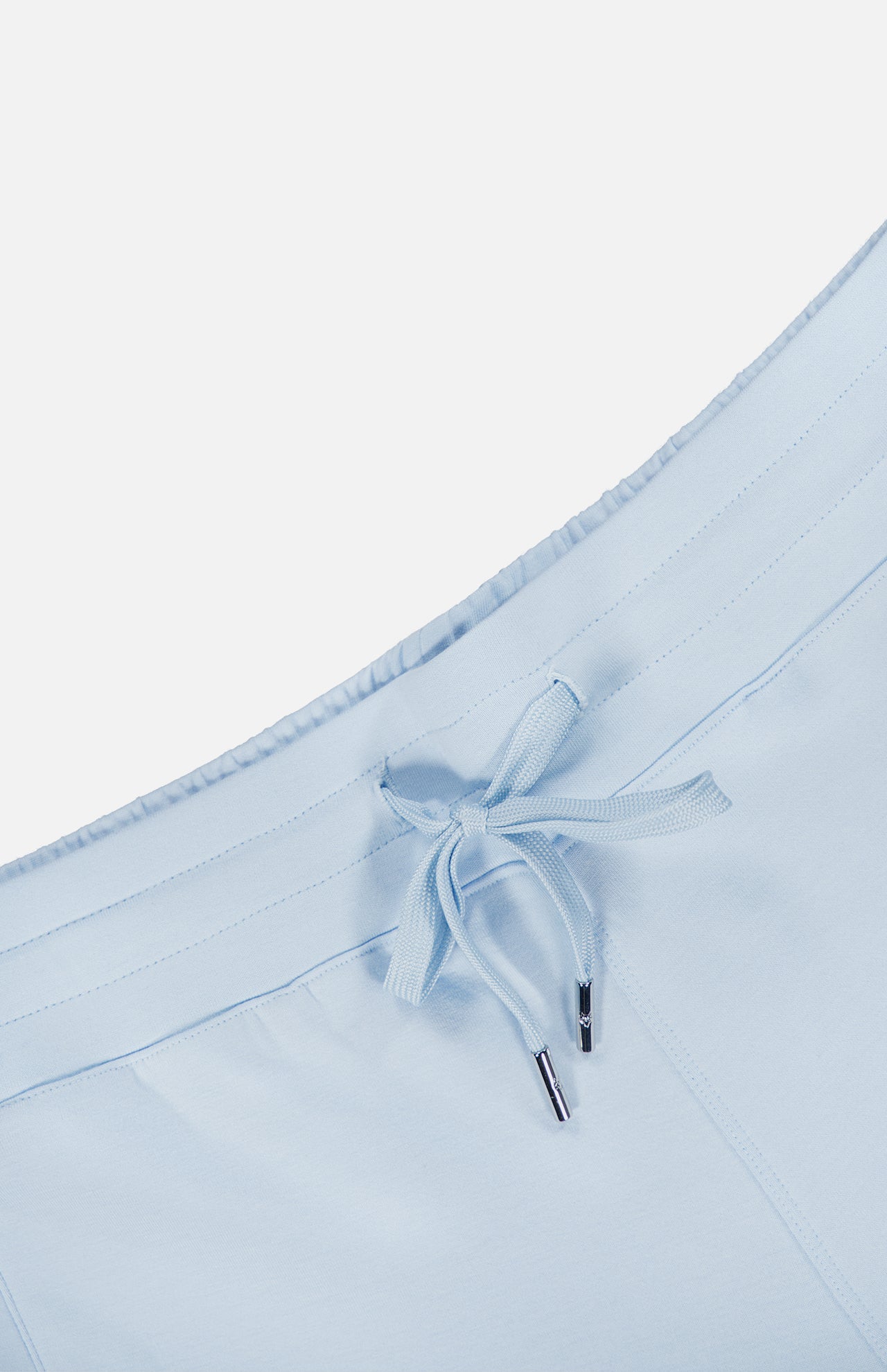 Close-up of the Ojai Wide Leg Pant by GREYSON, featuring a light blue cotton-blend waistband with a matching drawstring finished with silver metal tips, set against a plain white background.