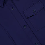 Close-up of the GREYSON Phoenix Belted Shirt Dress in navy blue, crafted from premium Italian stretch fabric, featuring a chest pocket with a flap and several matching blue buttons.