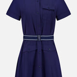 The Phoenix Belted Shirt Dress by GREYSON is a navy blue mini dress with short sleeves, a collared neckline, and a button-down front. Designed with modern sophistication in mind, it features a chest pocket, two front pockets, and a striped waist belt. Expertly crafted from Italian stretch fabric, this technical shirt dress offers a tailored and structured silhouette.