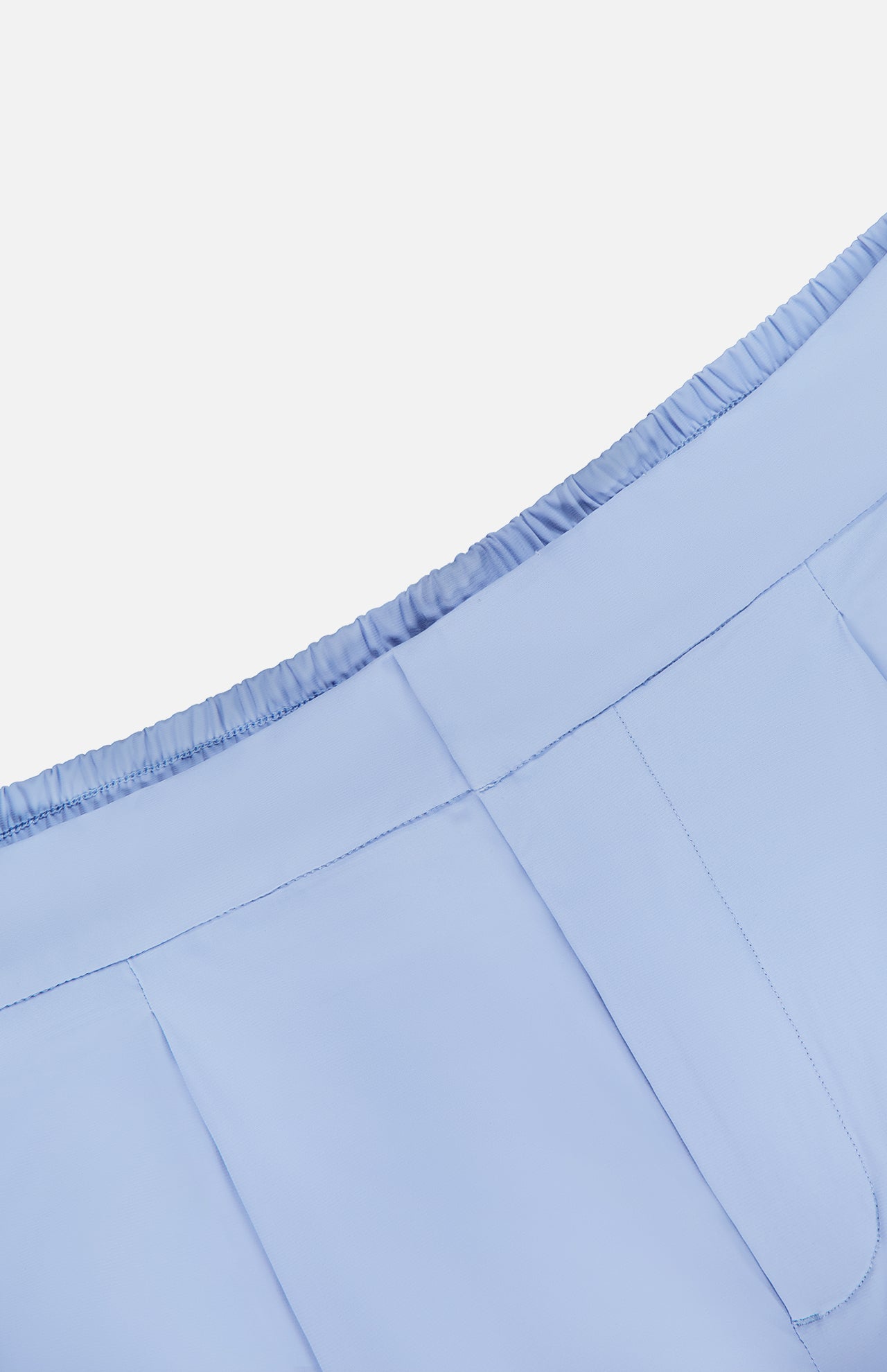 Close-up of the waistband and upper section of the light blue Phoenix Wide Leg Trouser Pant by GREYSON, featuring an elastic back and visible stitching details on a white background.