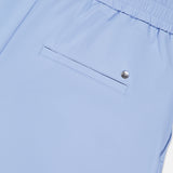 Close-up of the Phoenix Wide Leg Trouser Pant by GREYSON in light blue, showcasing an elastic waistband and a single back pocket with a button closure.