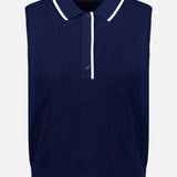 The GREYSON Pointelle Sleeveless Polo Top is a navy knit polo crafted from technical knit fabric with a textured diamond pattern. Featuring three buttons and a white-trimmed collar, this dark blue sleeveless top is shown against a plain white background.