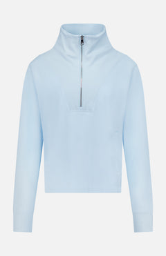 Introducing the GREYSON Soleil 1/2 Zip Pullover Sweater: a light blue, slim-fit long-sleeve with a high collar, ribbed cuffs, and half-zip front closure. Expertly crafted from Italian double-faced fabric, this minimalistic and sporty sweater features no visible logos or patterns. Designed for both outdoor activities and everyday wear, it offers UV and thermal protection for superior comfort.