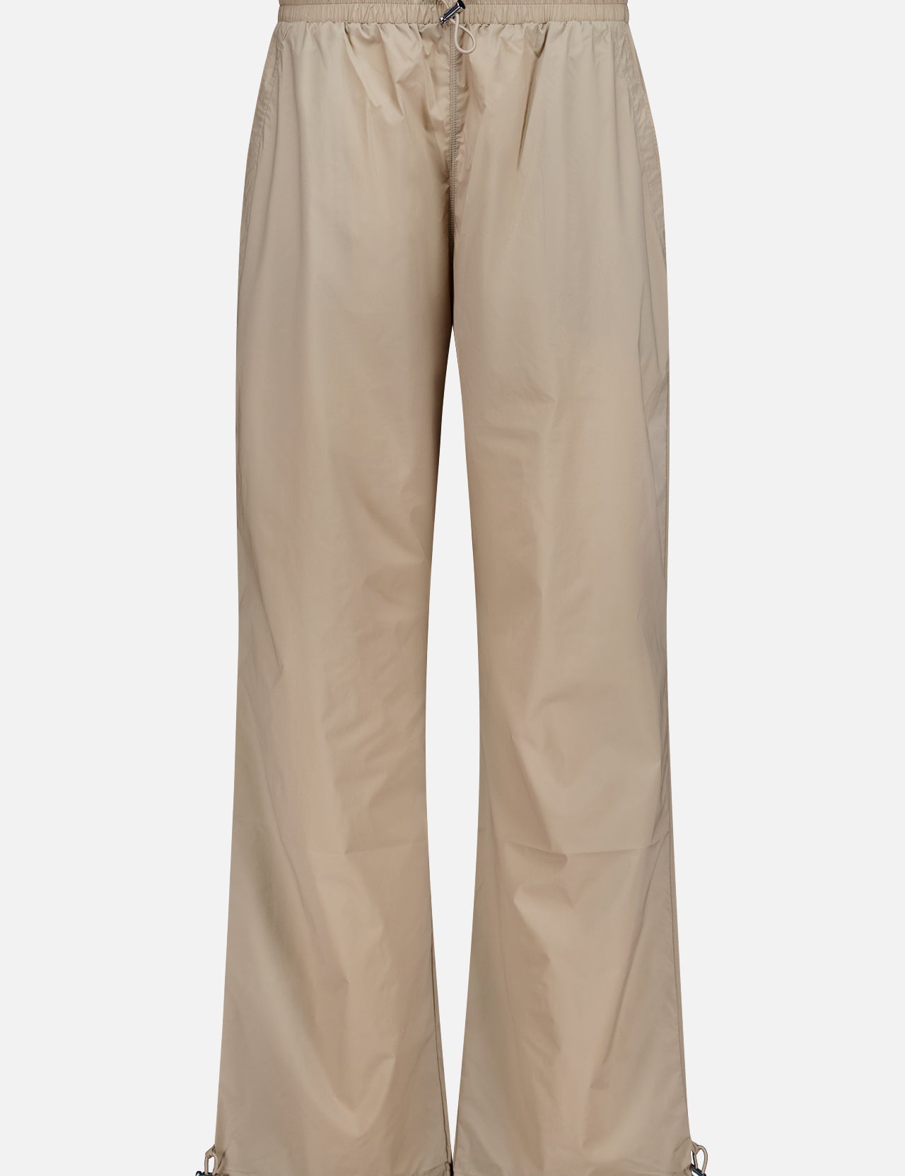 Greyson Wide Nylon Pant in beige, featuring a wide-leg athletic fit with an elastic waist, front drawstring, and adjustable toggles at the hems.