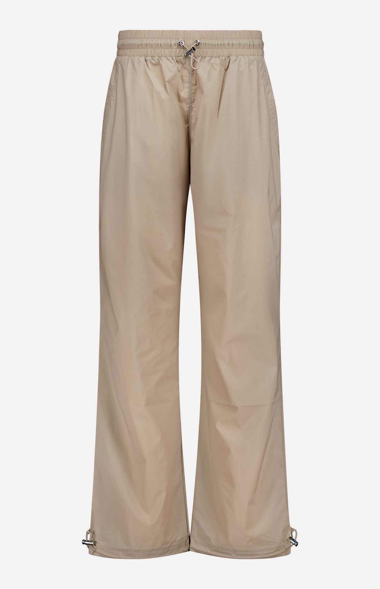 Greyson Wide Nylon Pant in beige, featuring a wide-leg athletic fit with an elastic waist, front drawstring, and adjustable toggles at the hems.