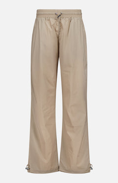 Greyson Wide Nylon Pant in beige, featuring a wide-leg athletic fit with an elastic waist, front drawstring, and adjustable toggles at the hems.
