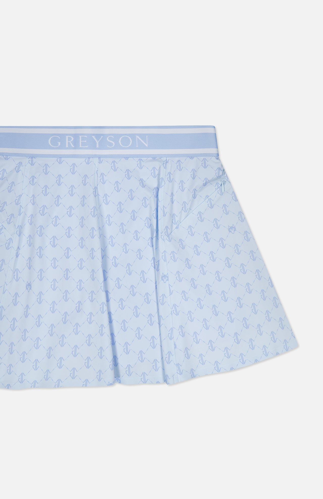 The Wolf Links Phoenix Flare Mini Skirt by GREYSON features a light blue color with a repeating pattern and a wide waistband emblazoned with the brand’s name in white. The fabric has a subtle sheen, and the skirt showcases a flared silhouette with built-in shorts for added comfort.
