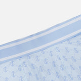 The GREYSON Wolf Links Phoenix Flare Mini Skirt features a light blue hue with a subtle geometric pattern that incorporates repeating shapes and a distinctive Wolf Links monogram. Designed for both style and comfort, it includes built-in shorts for added coverage, while the matching waistband is accented with two thin white stripes along the top edge.