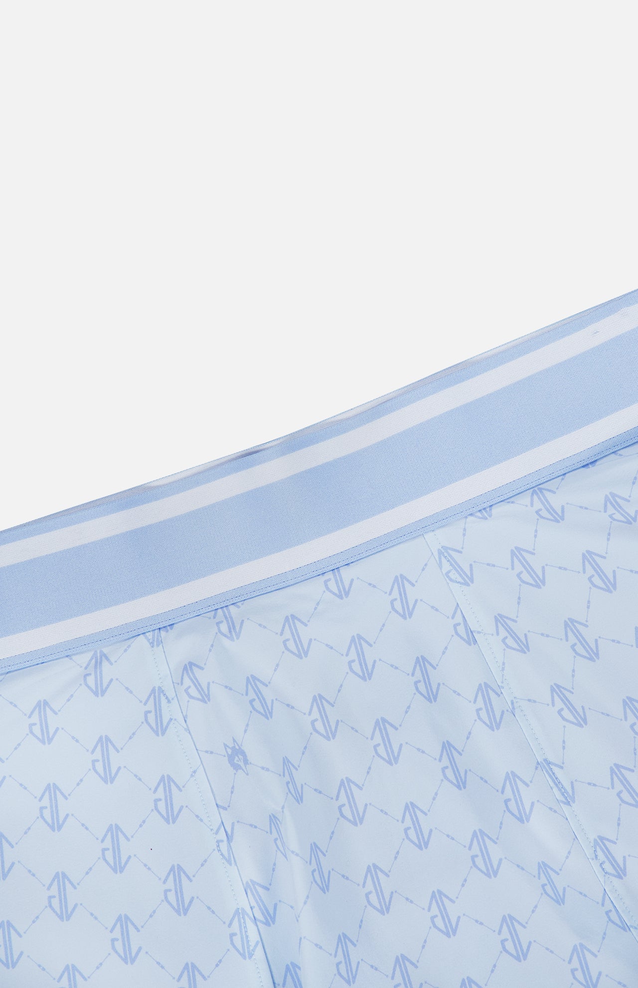 The GREYSON Wolf Links Phoenix Flare Mini Skirt features a light blue hue with a subtle geometric pattern that incorporates repeating shapes and a distinctive Wolf Links monogram. Designed for both style and comfort, it includes built-in shorts for added coverage, while the matching waistband is accented with two thin white stripes along the top edge.