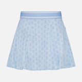 The GREYSON Wolf Links Phoenix Flare Mini Skirt features a light blue hue with a subtle all-over repeating wolf links monogram pattern, a wide waistband, and built-in shorts for added comfort, shown against a plain white background.