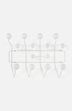 The HERMAN MILLER Eames Hang-It-All is a modern, minimalist coat rack with multiple white round-knob hooks arranged in an artistic geometric pattern, inspired by classic Eames design.