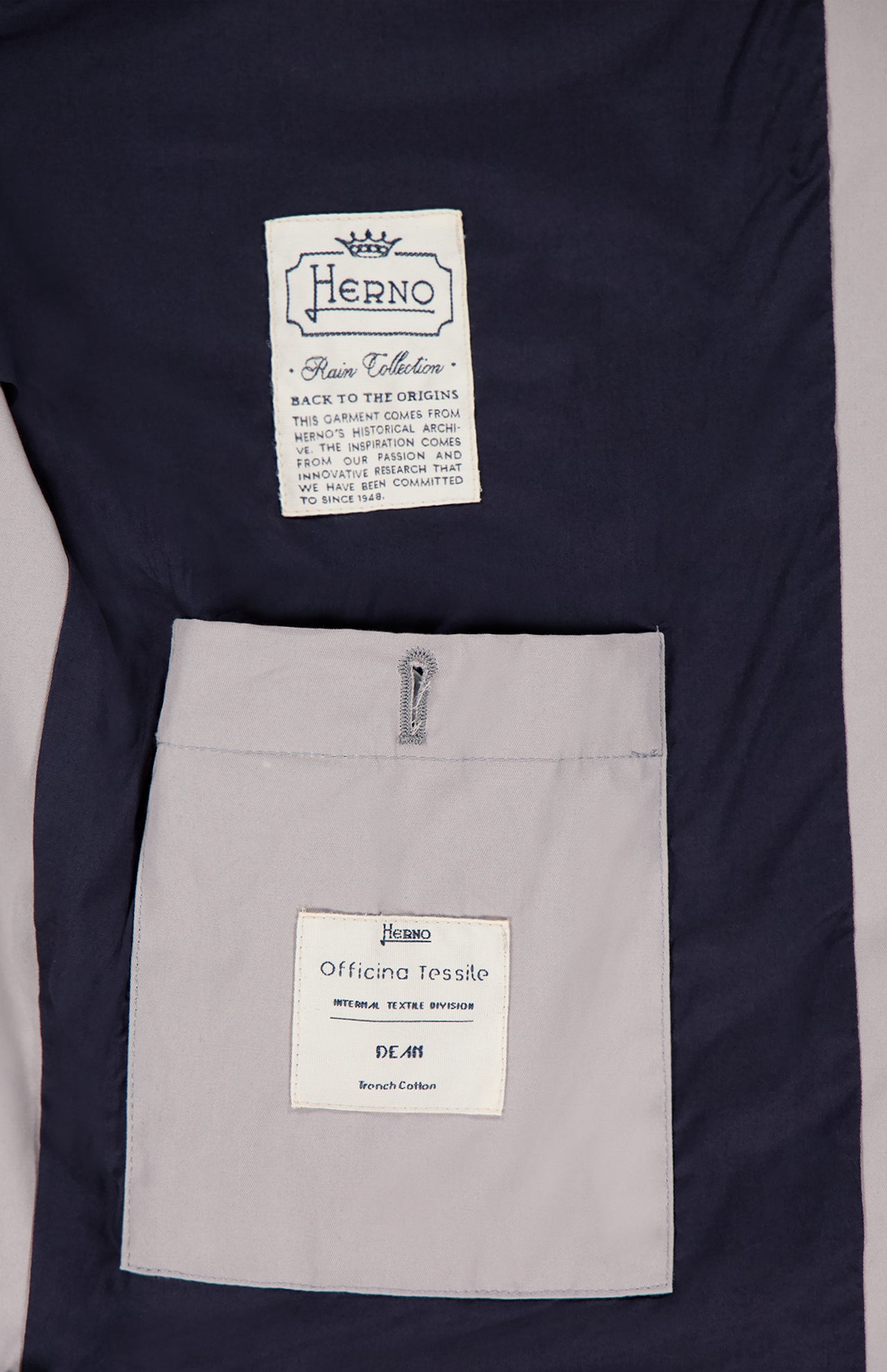 Close-up of the Dean Cotton Bomber Zip Jacket by HERNO in light grey, highlighting two inner labels—one reading Herno Rain Collection and another labeled Officina Tessile—a refined pick for men’s spring outerwear.