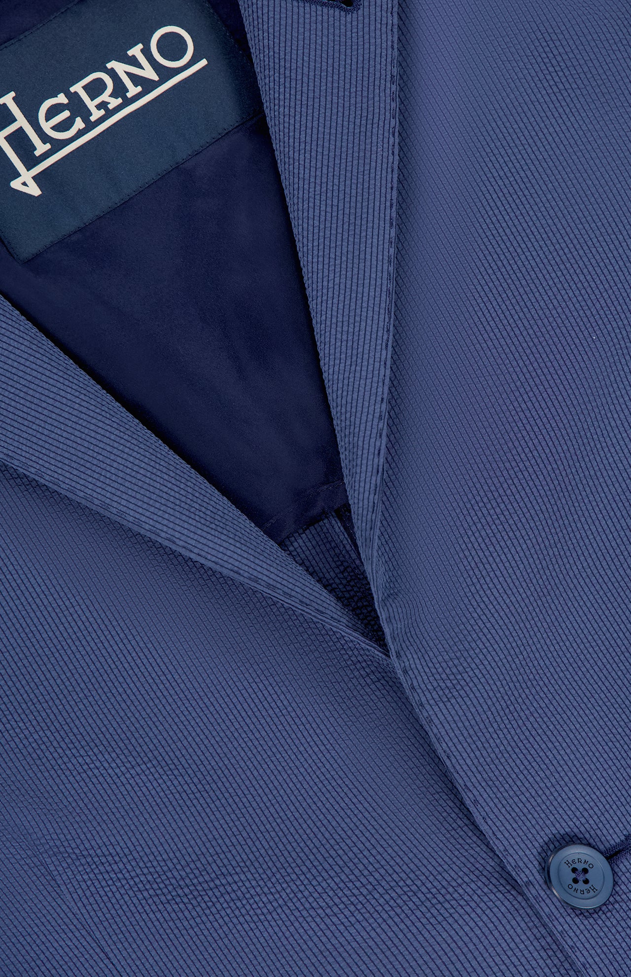 Close-up of the textured Seersucker 2 Button Blazer by HERNO, ideal for formal events, featuring a button, lapel, and an inner HERNO label.