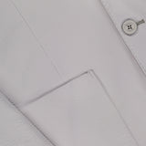 Close-up of HERNO's Seersucker 2 Button Blazer for men in light grey, highlighting two buttons, a lapel, front pocket, and a subtle woven texture for an elegant finish.