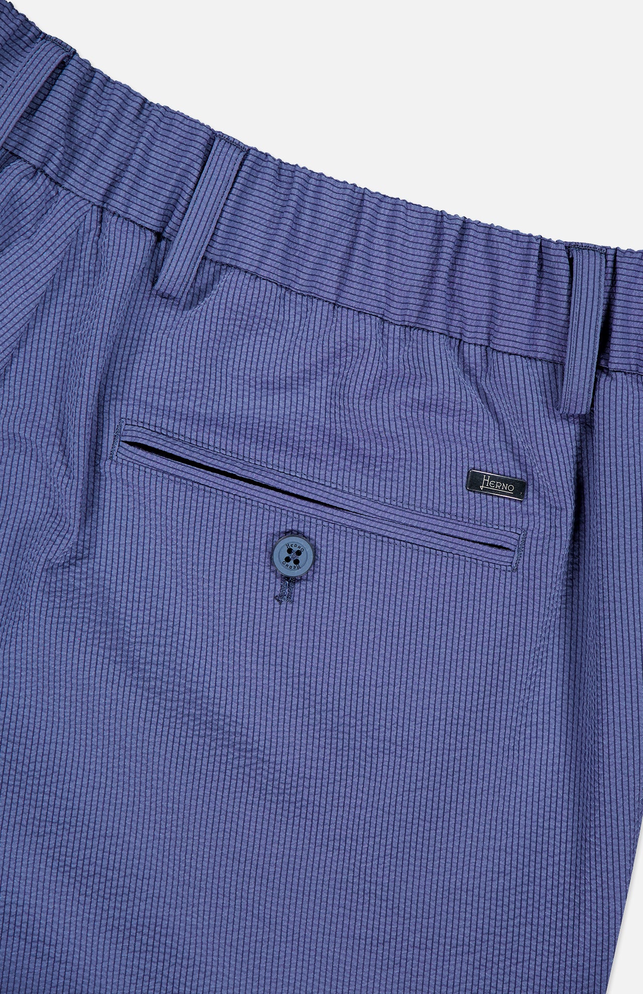 Close-up of HERNO Seersucker Trouser Pant, featuring a blue seersucker fabric, elasticized waistband, belt loops, buttoned back pocket, and a small Legno label—ideal for comfortable spring and summer wear.