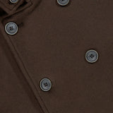 Close-up of the HERNO Wool Blend Double Breasted Peacoat in brown, showcasing its black buttons and smooth wool-blend texture. This timeless men’s outerwear piece is accentuated by detailed images of its flap and button details.