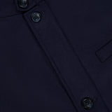 Close-up of the HERNO Wool Silk Blend Jacket in dark navy blue, featuring a round neckline, three black buttons, and a horizontal chest pocket. This refined men’s designer outerwear piece showcases a subtle textured pattern that adds depth to the luxurious wool-silk blend fabric for an elevated, sophisticated look.