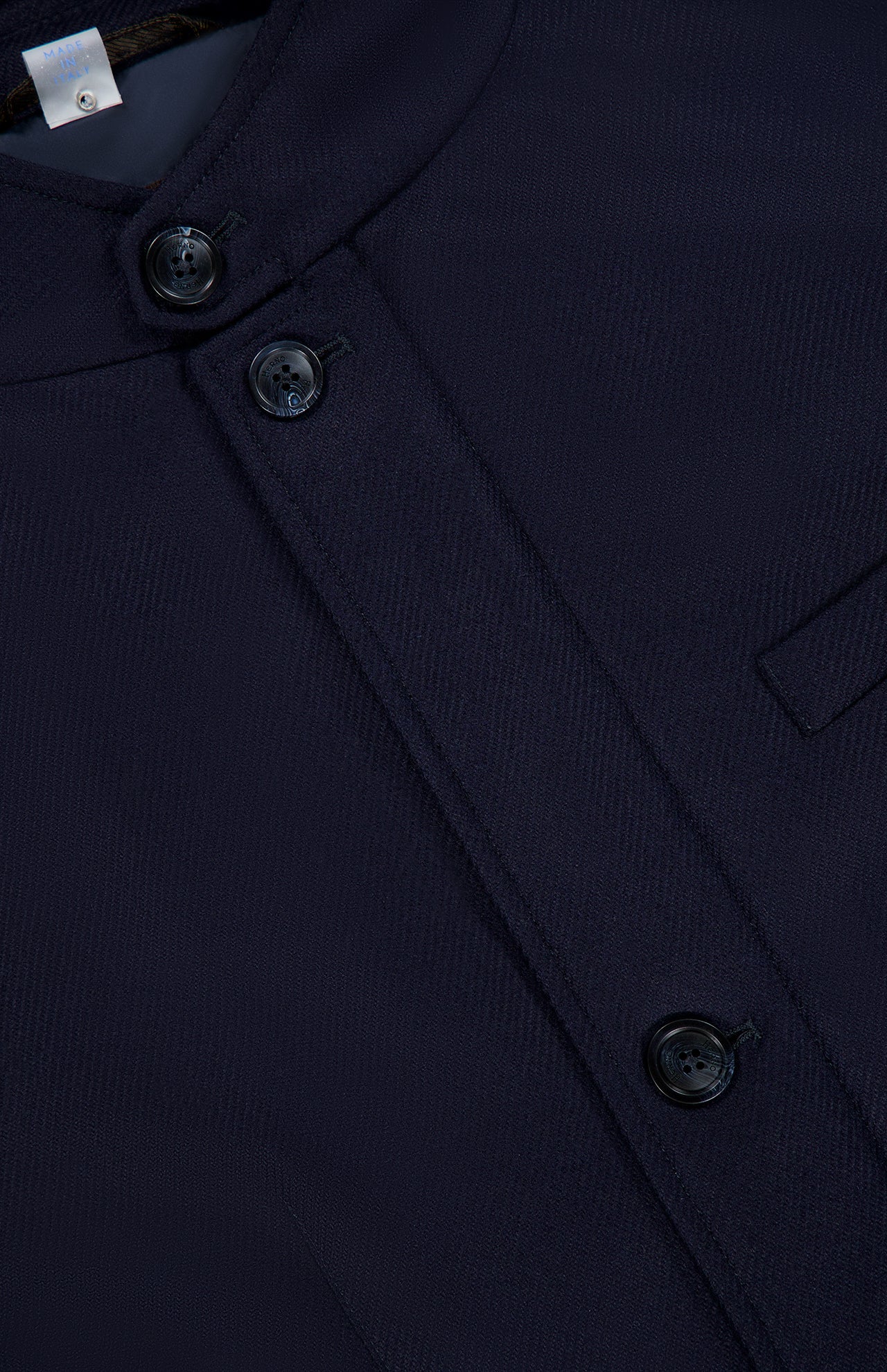 Close-up of the HERNO Wool Silk Blend Jacket in dark navy blue, featuring a round neckline, three black buttons, and a horizontal chest pocket. This refined men’s designer outerwear piece showcases a subtle textured pattern that adds depth to the luxurious wool-silk blend fabric for an elevated, sophisticated look.