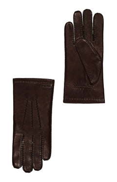 A pair of HESTRA Edward Gloves in dark brown leather with wool lining are shown flat on a white background; one displays the palm, the other the back with visible handsewn stitching.