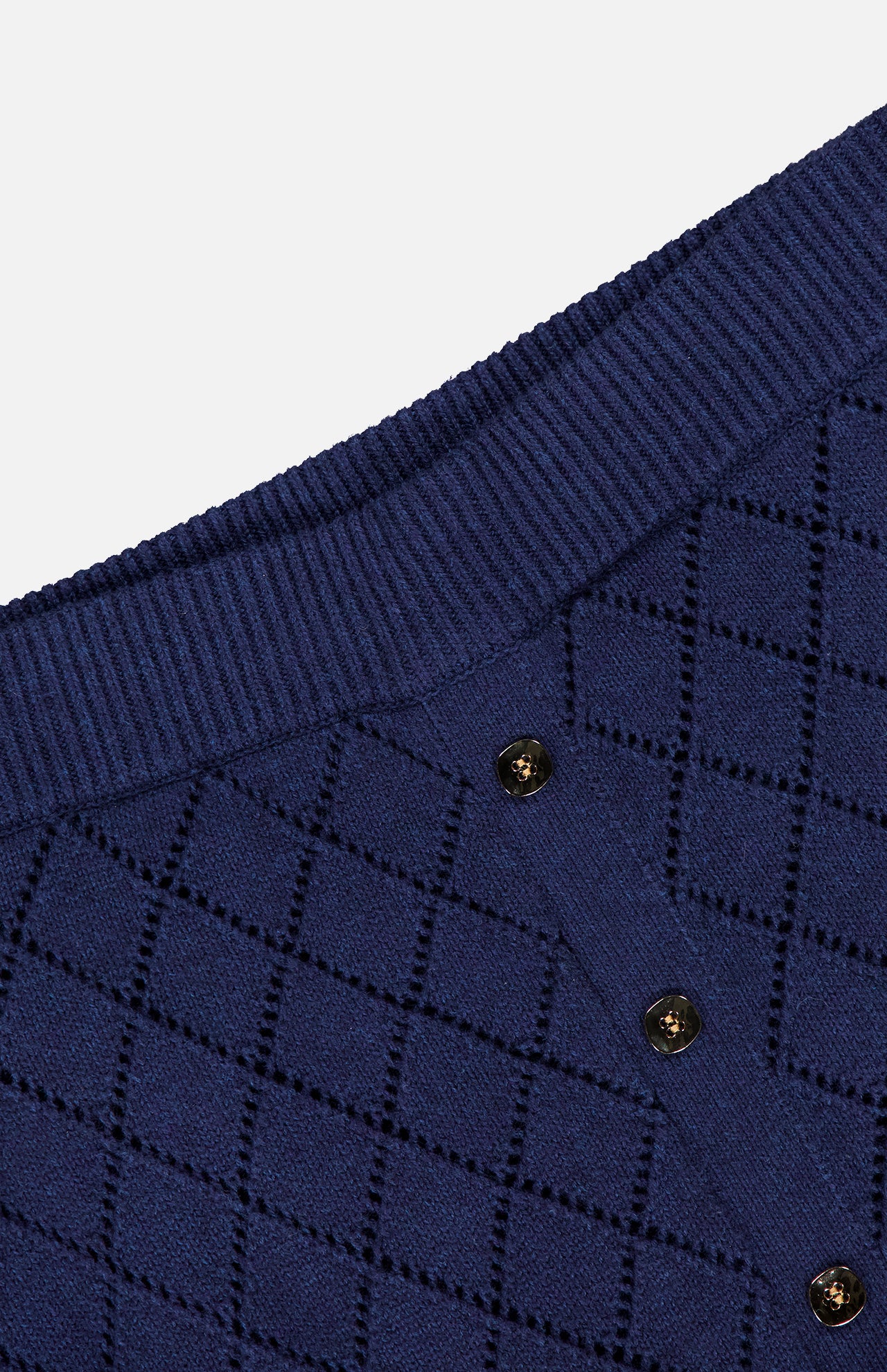 Close-up of the HEVRON Mia Knit Midi Skirt in navy, featuring a diamond pointelle pattern, three dark buttons, and a thick ribbed border.