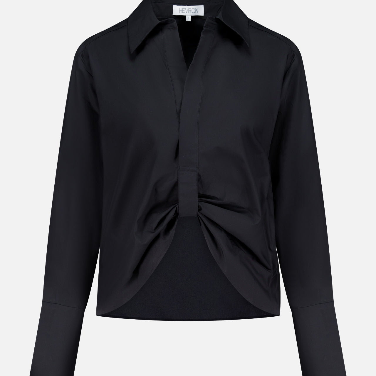 The Paola Adjustable Front Top by HEVRON is a black, long-sleeve collared blouse featuring a front knot detail and wide cuffs, shown against a plain white background.