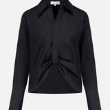 The Paola Adjustable Front Top by HEVRON is a black, long-sleeve collared blouse featuring a front knot detail and wide cuffs, shown against a plain white background.