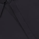 Close-up of the Paola Adjustable Front Top by HEVRON, featuring a hidden button placket, adjustable epaulette detail, and a glimpse of a white label at the neckline.