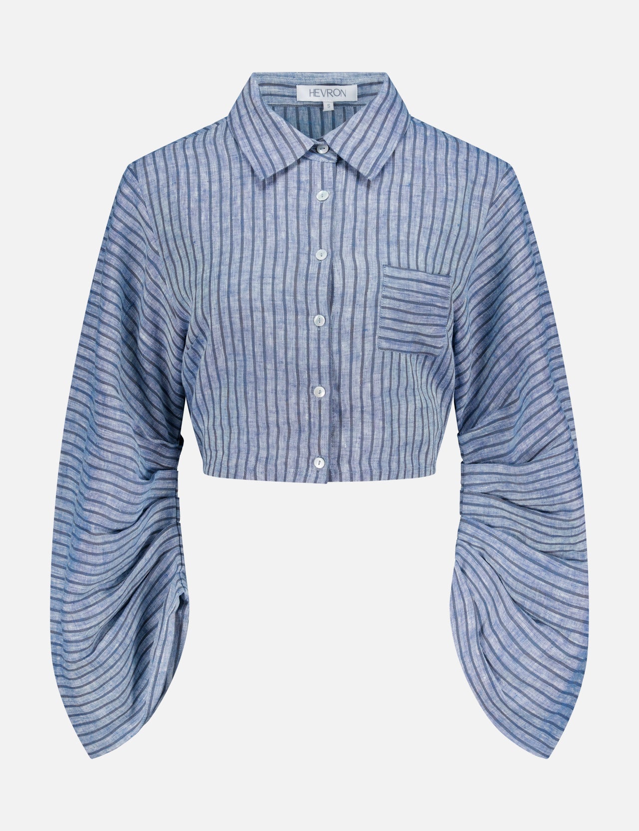 The Raquel Pleated Sleeves Top by HEVRON features blue stripes, a cropped button-up design, collar, chest pocket, and exaggerated pleated sleeves for a modern touch.